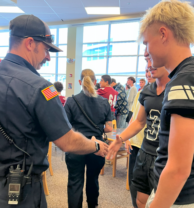 Fire Fighter shacks football players hand