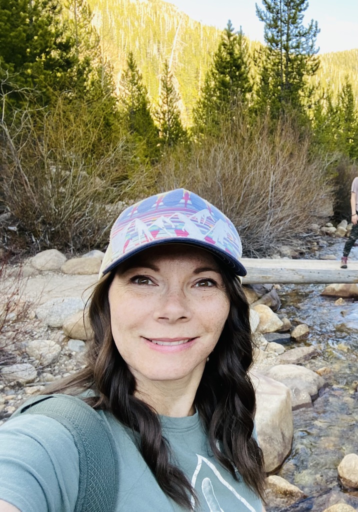 Profile picture of Dani Henrie near a mountain stream. 