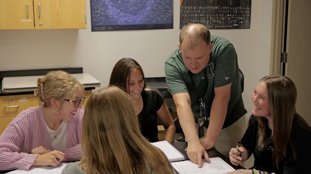 teacher helping group of students 