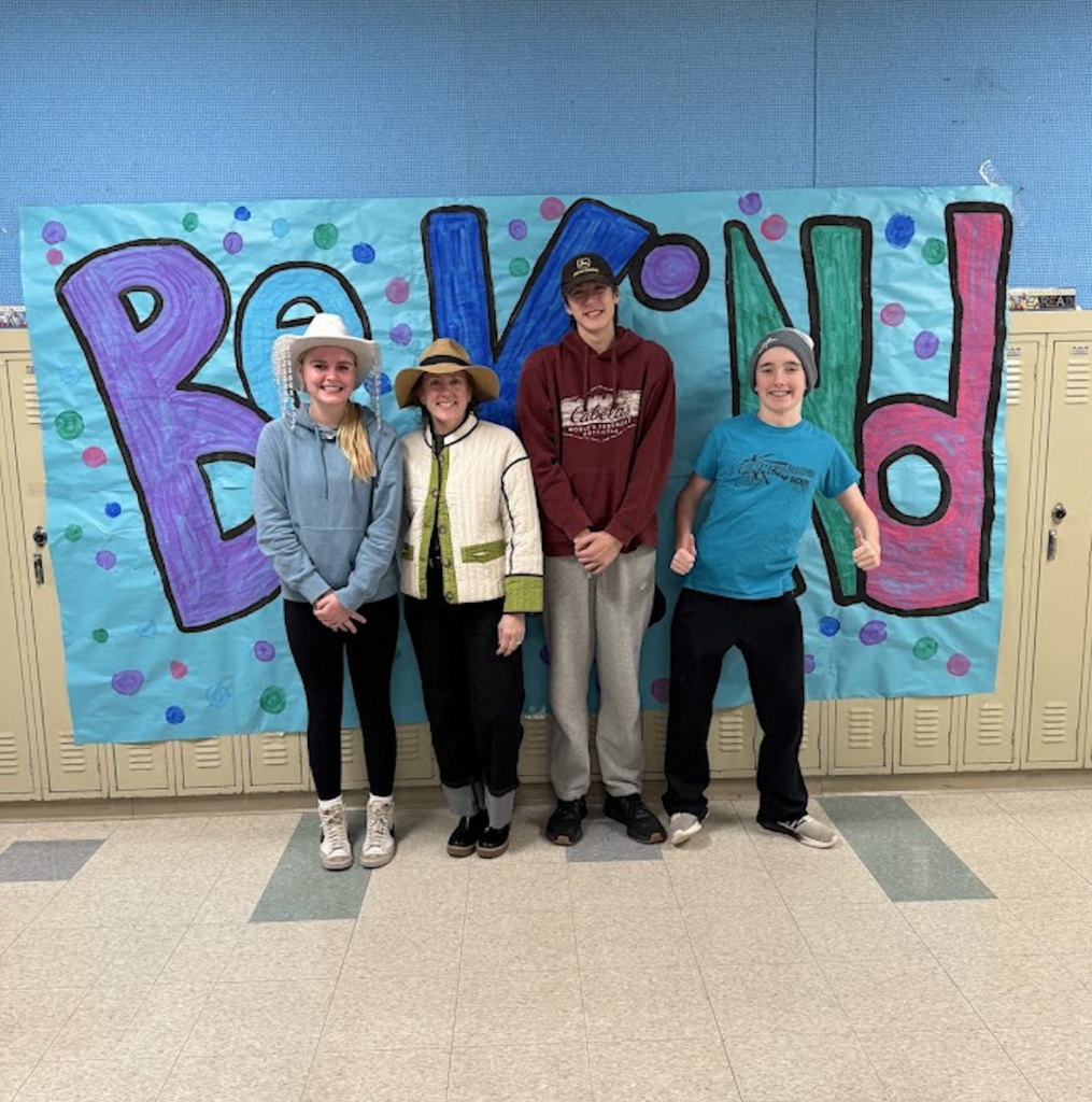 be kind banner and students standing in front