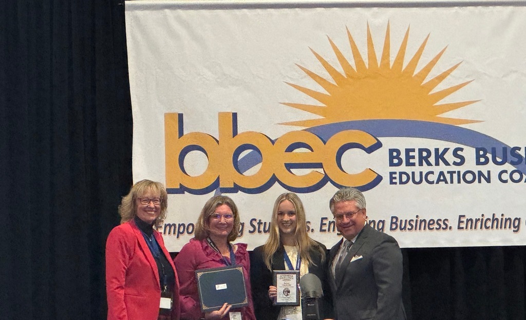 female student emma holding certificate along with 3 professionals from BBEC