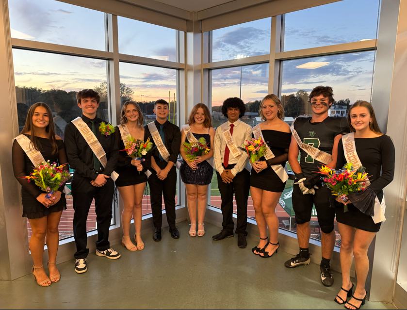 students lined up in front of scenic sunset in homecoming attire