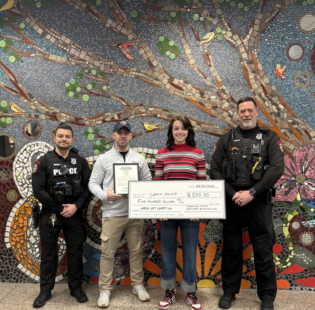 Student Sophia Moyer holds a large $500 check with representatives from Police Department in their uniforms