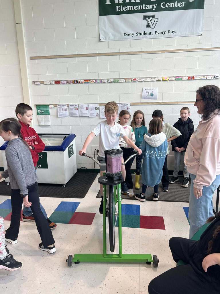 child smiling on blender bike - making a smoothie as he peels