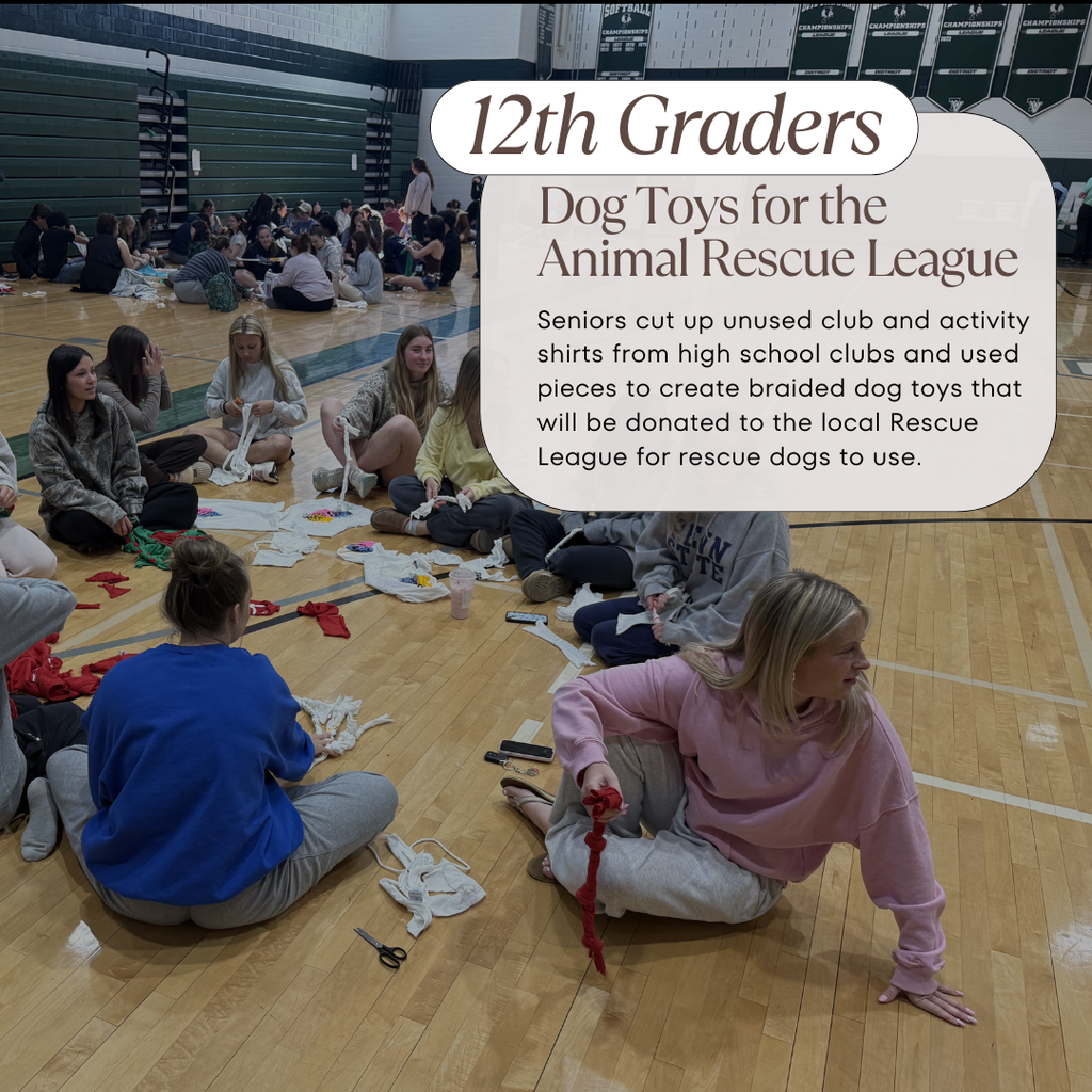 12th grade students sitting on the floor of a gym while using tshirt pieces to braid dog toys