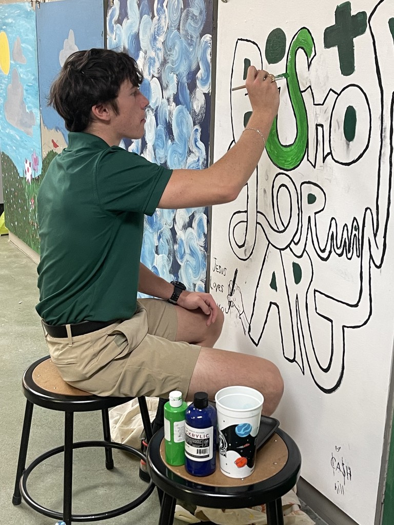 Student painting a classroom mural