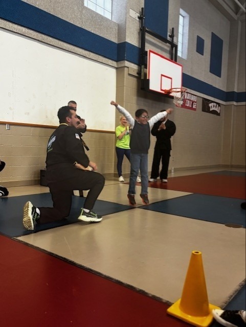 student jumping after breaking a board in karate class