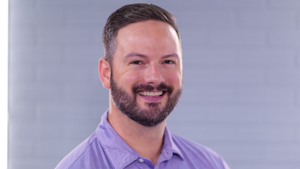man with beard wearing purple collared shirt