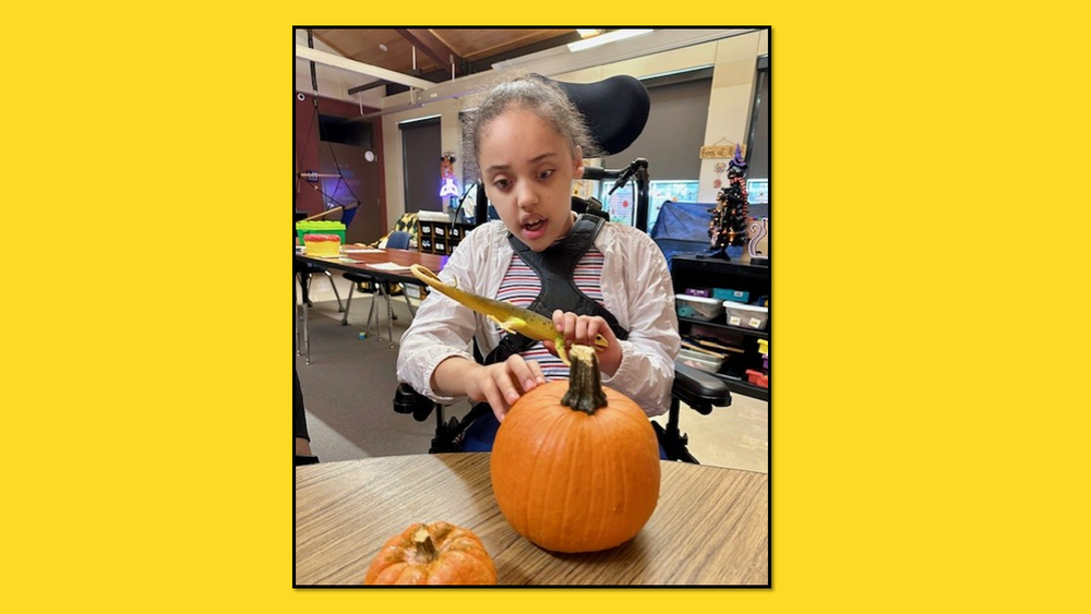 Student looking at a pumpkin