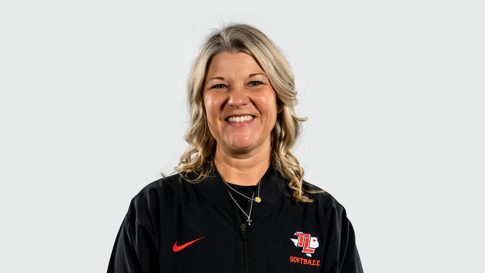 Caucasian woman with long blonde hair wearing a black polo