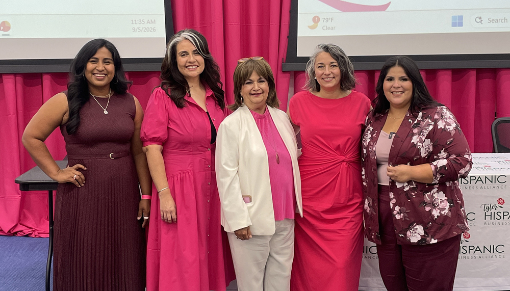 five Hispanic women wearing pink standing next to each other