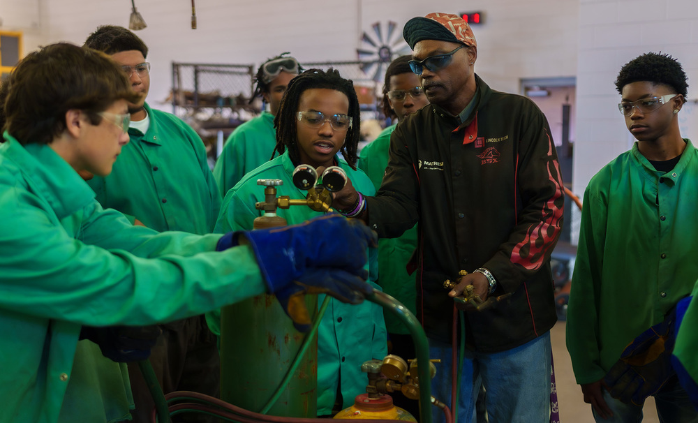 teens working on welding tank