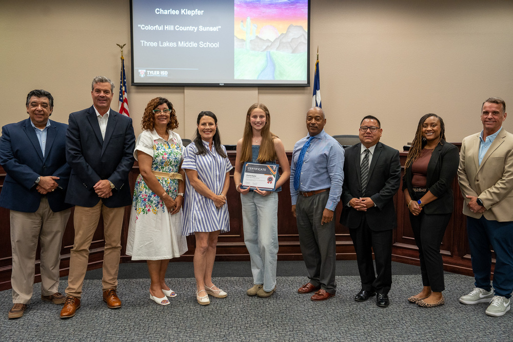 men and women in a line next to each other with a teen girl in the middle holding a certificate