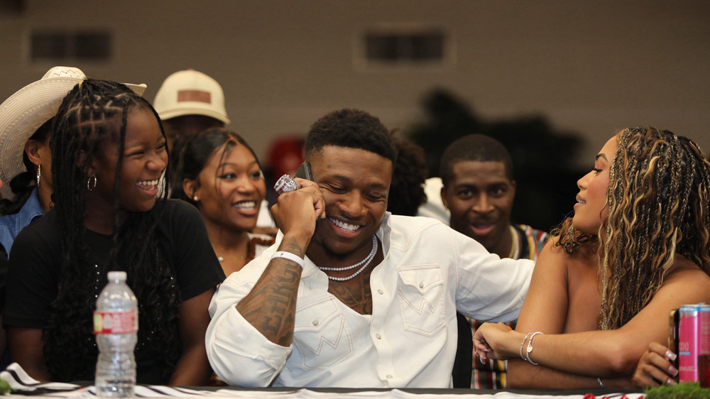 man talking on phone with a woman sitting on each side of him