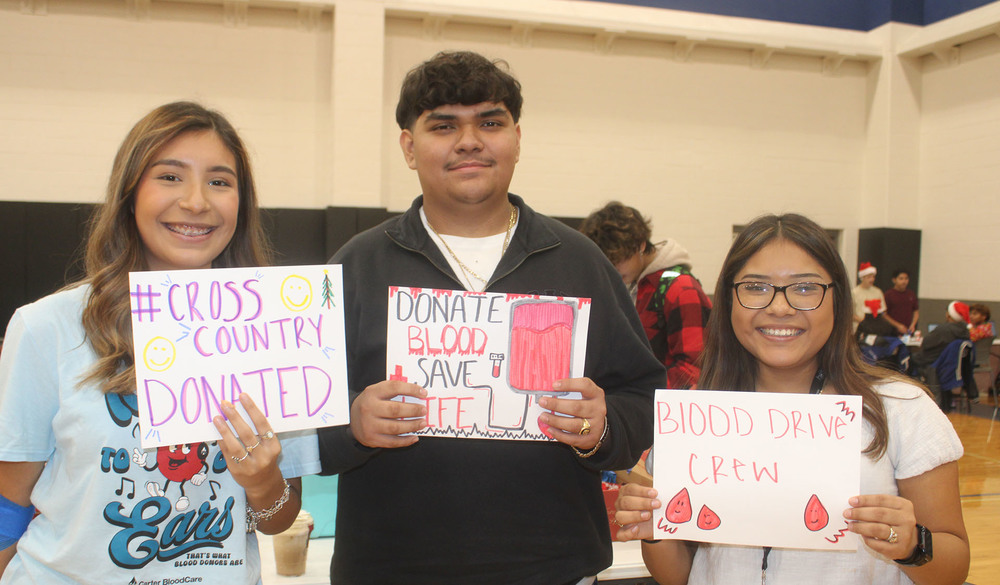 three teens holding signs that say they donated in the blood drive