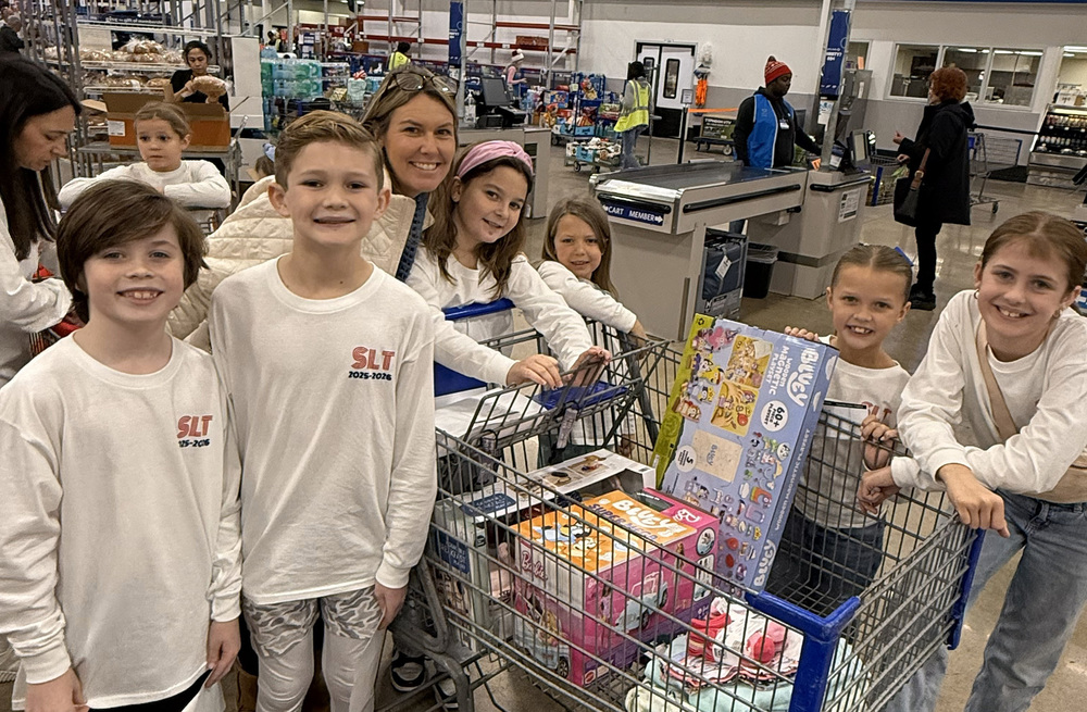 kids and woman in store with shopping cart full of toys