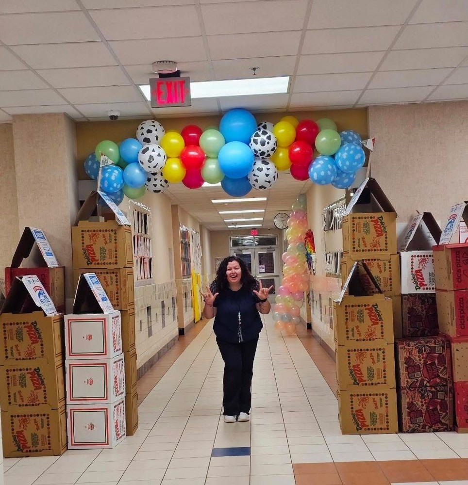 teacher signing i love you under pizza box castle and balloon arch