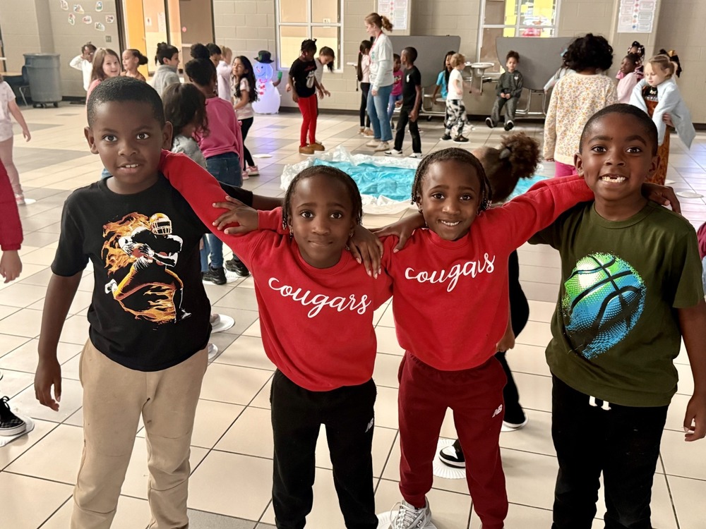 4 boys hugghing each other and smiling