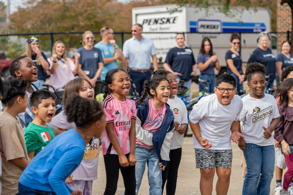 young boys and girls screaming with excitement as they were given new bikes