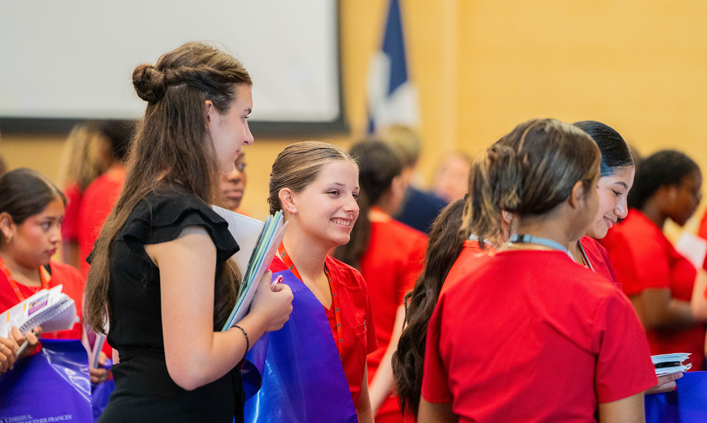 teen girls in a group smiling as they listen to someone explain an xray