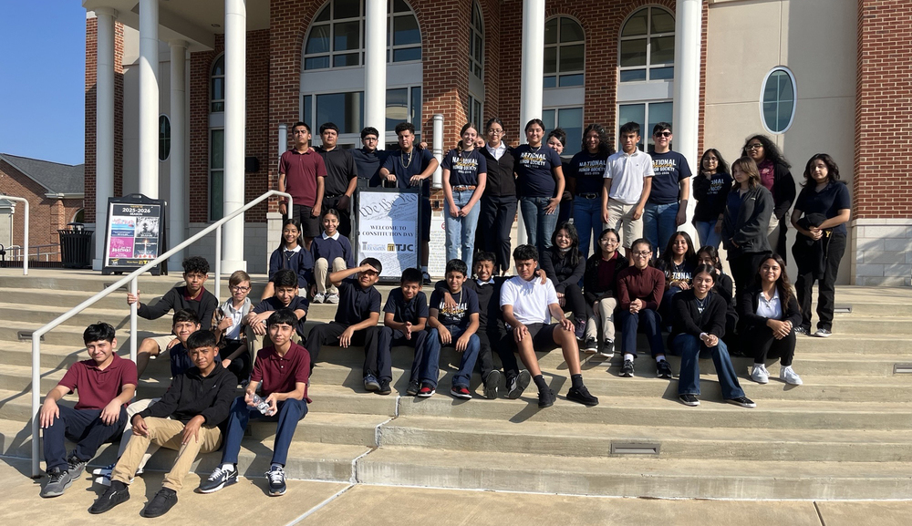 teen boys and girls outside of brick building on steps