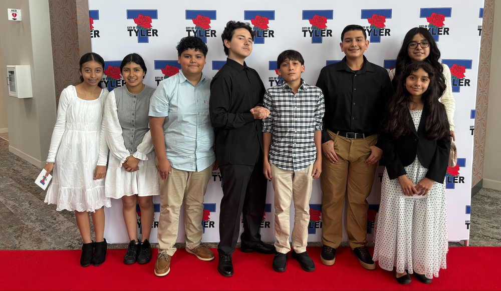 middle school age boys and girls in church clothes standing beside each other