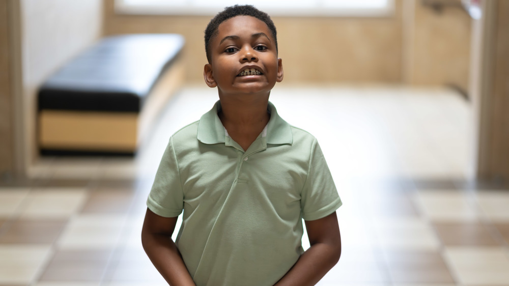 young African American boy in hallway smiling at the camera