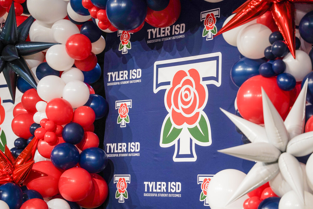 Tyler ISD banner surrounded by red, white, and blue balloons