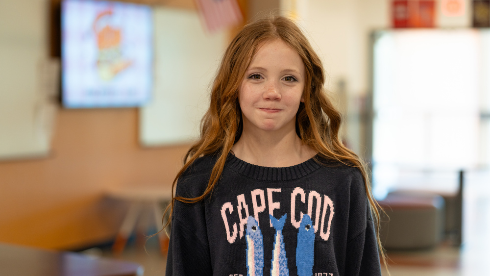 middle school girl with long red hair in classroom