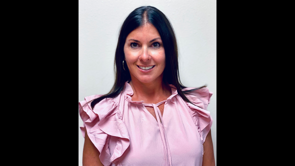 woman with long dark hair wearing a pink blouse