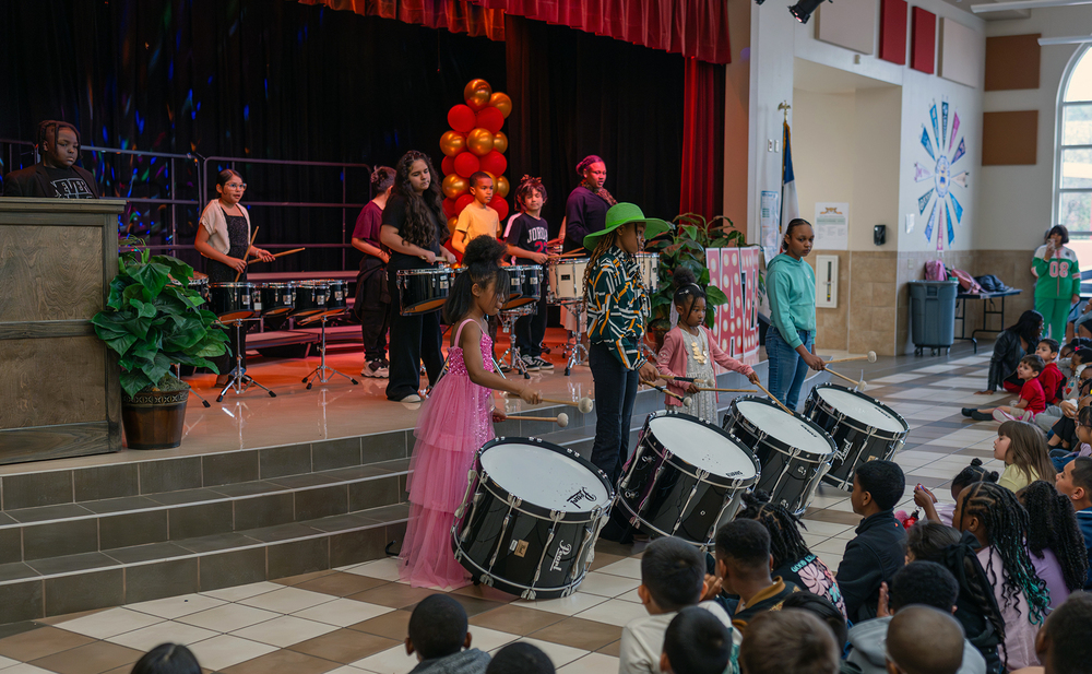 elementary age kids on stage playing drums