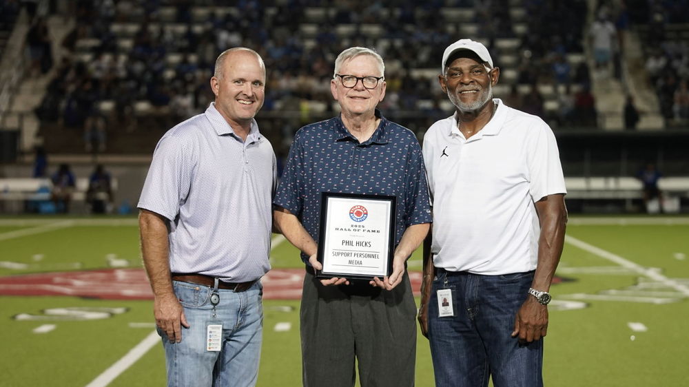 Three men standing on 50 yard line