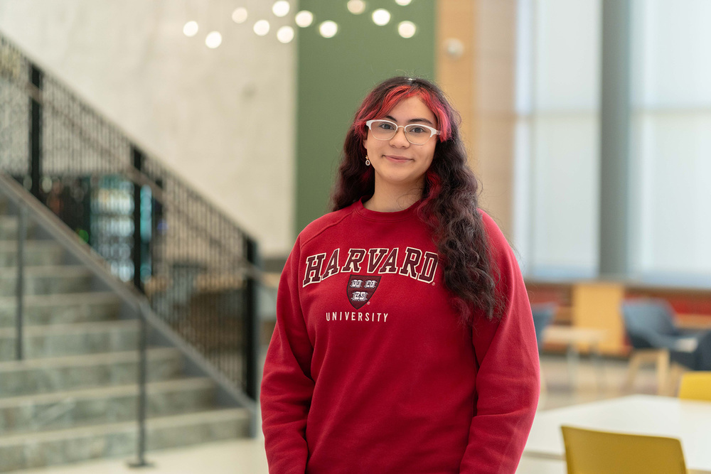 teen girl in red Harvard sweatshirt in front of staircase