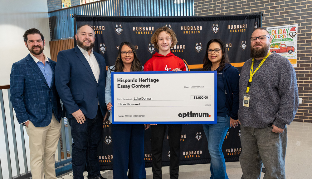teen boy, two women and three men holding a giant check 