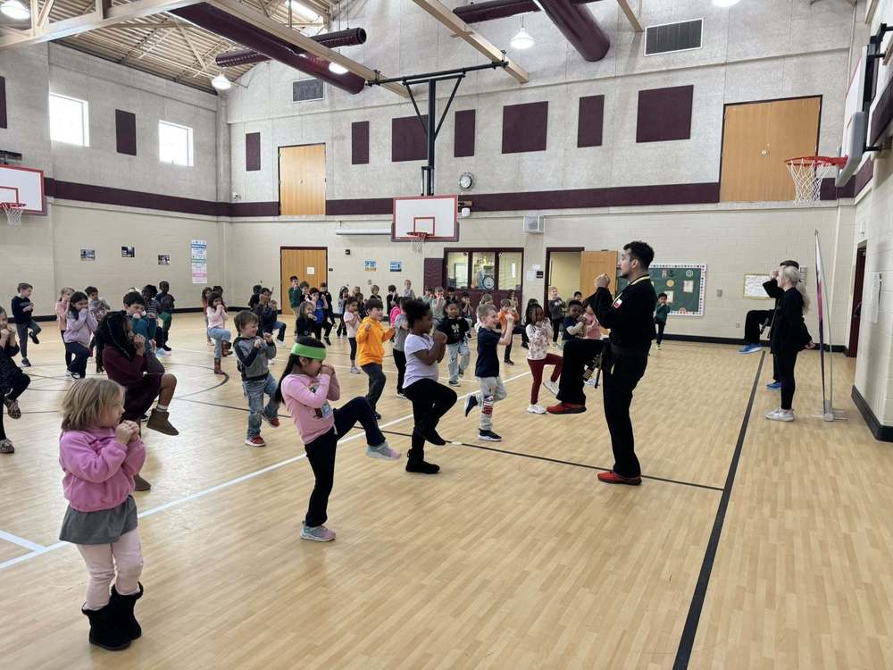Students in the gym following instructor
