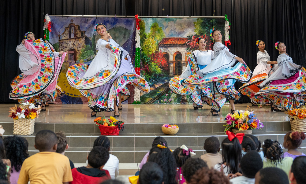 women dancing on stage on traditional Hispanic dresses