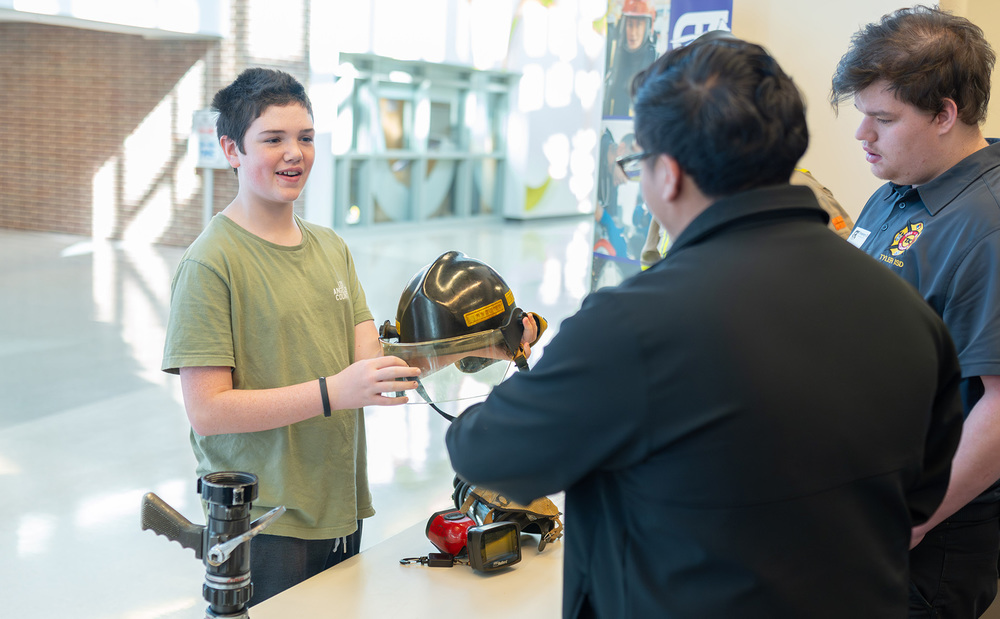 teen boys holding fire helmet