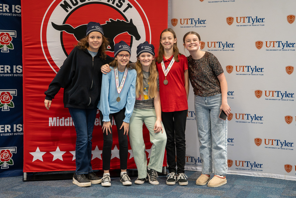 five teen kids standing beside each other, two wearing medals