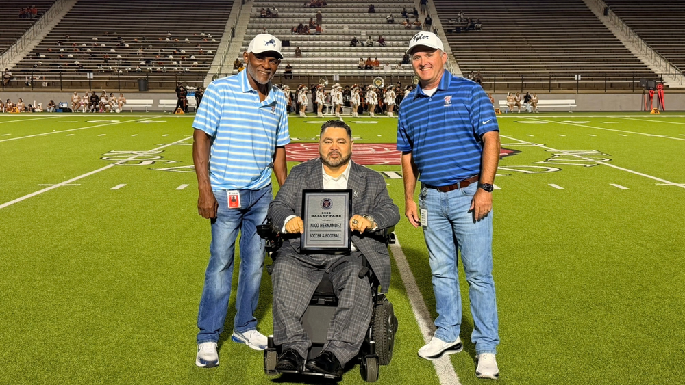 Nico Hernandez holding Hall of Fame plaque with Tyler ISD athletics officials