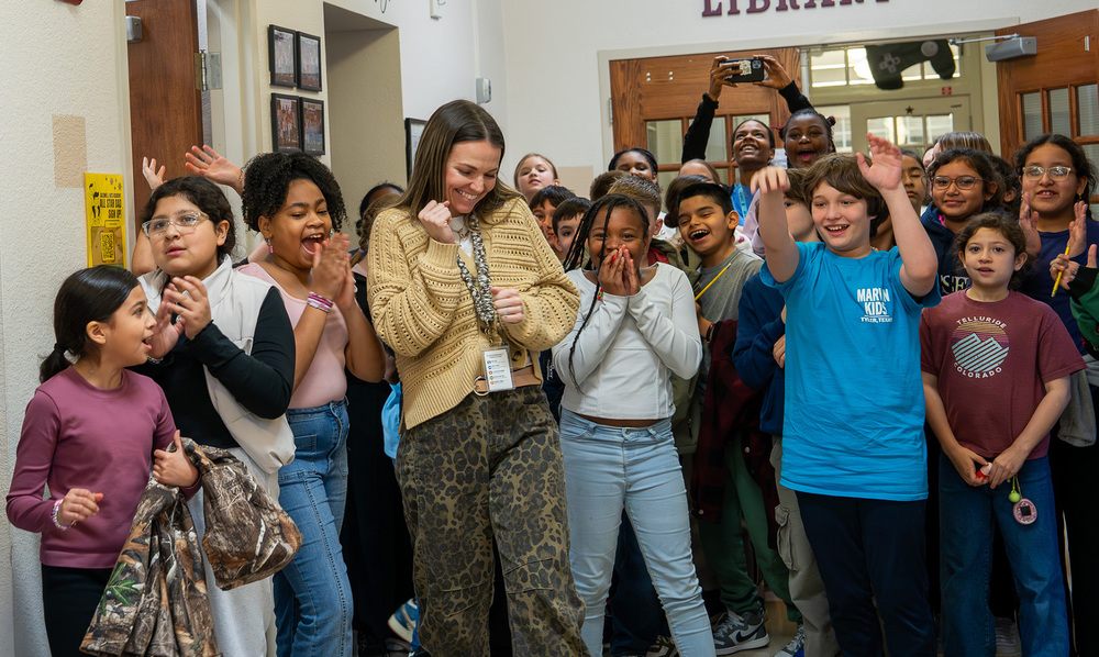 woman surrounded by kids clapping and celebrating
