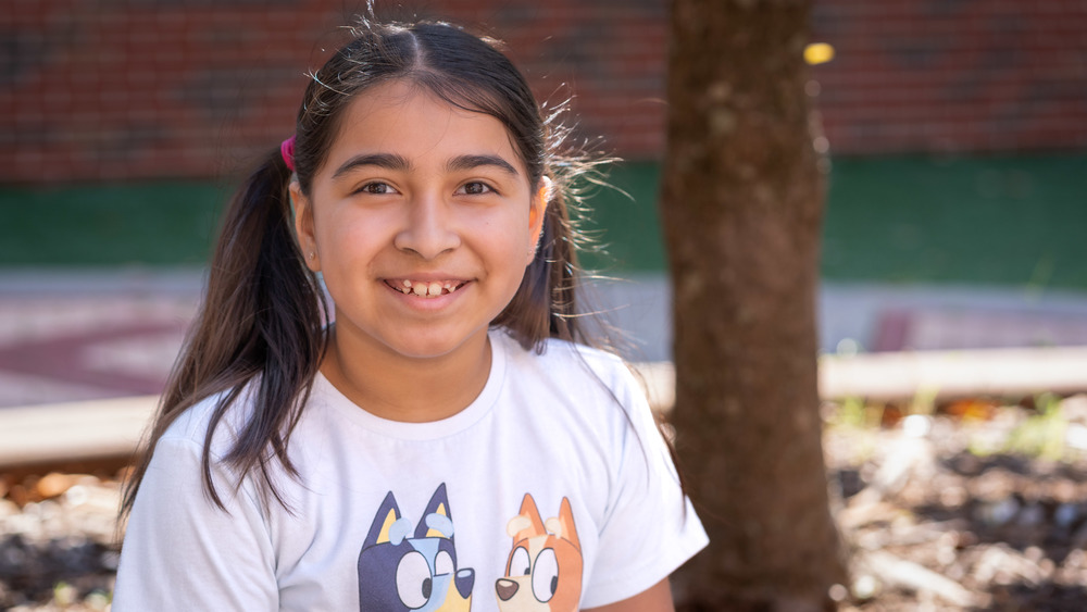 young girl with brown hair wearing pigtails and a white t-shirt
