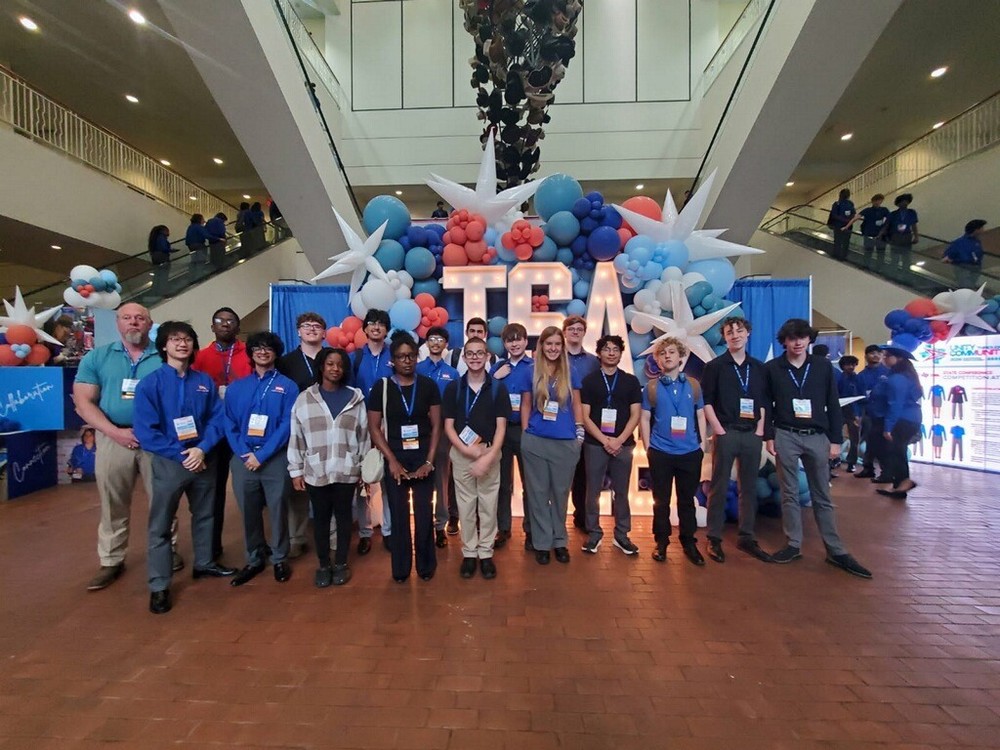 teen boys and girls in a hallway wearing lanyards