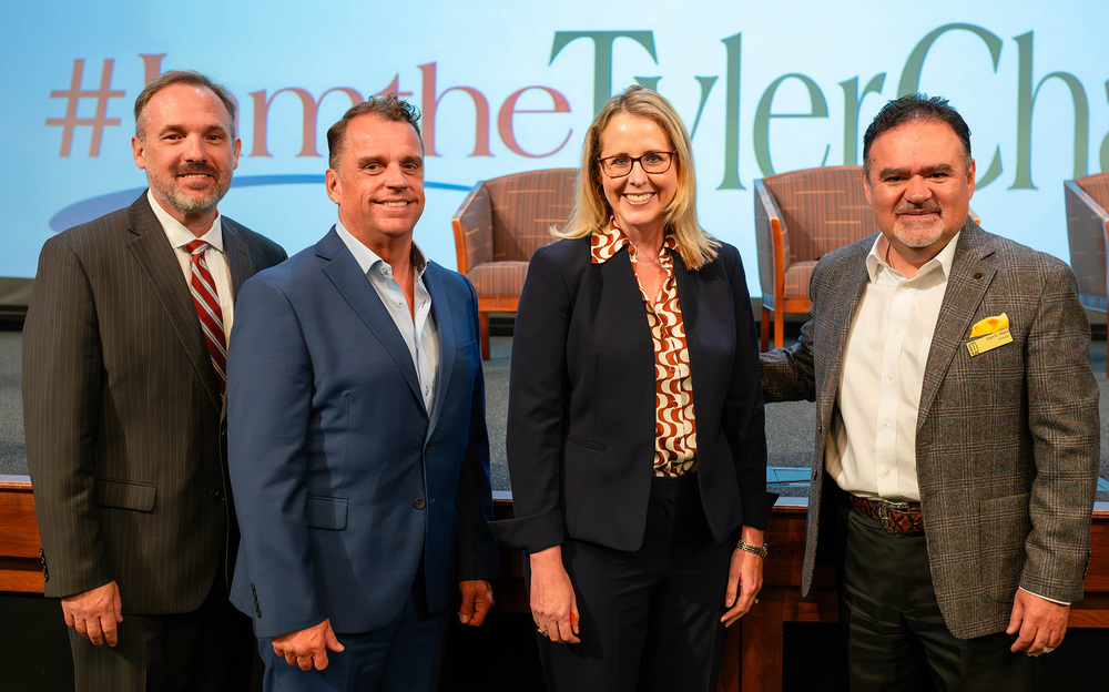 three men and a woman standing next to each other
