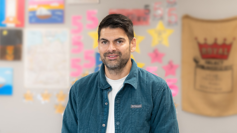man with dark hair and beard standing in hallway