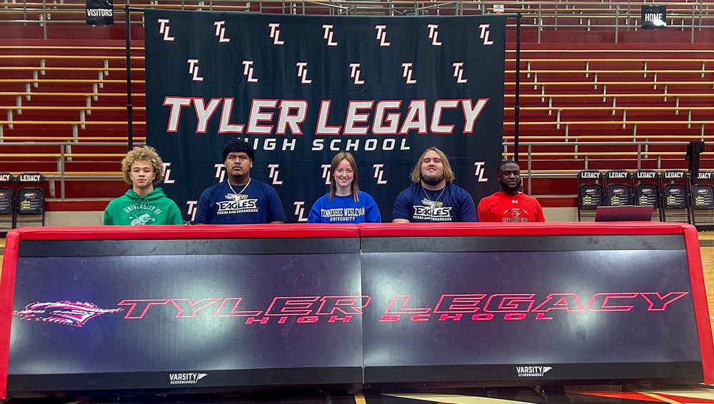 teen boys and a girl sitting at a table in gym