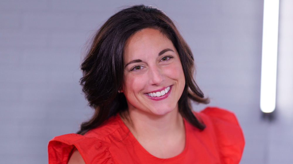 woman with dark shoulder length hair wearing a red blouse