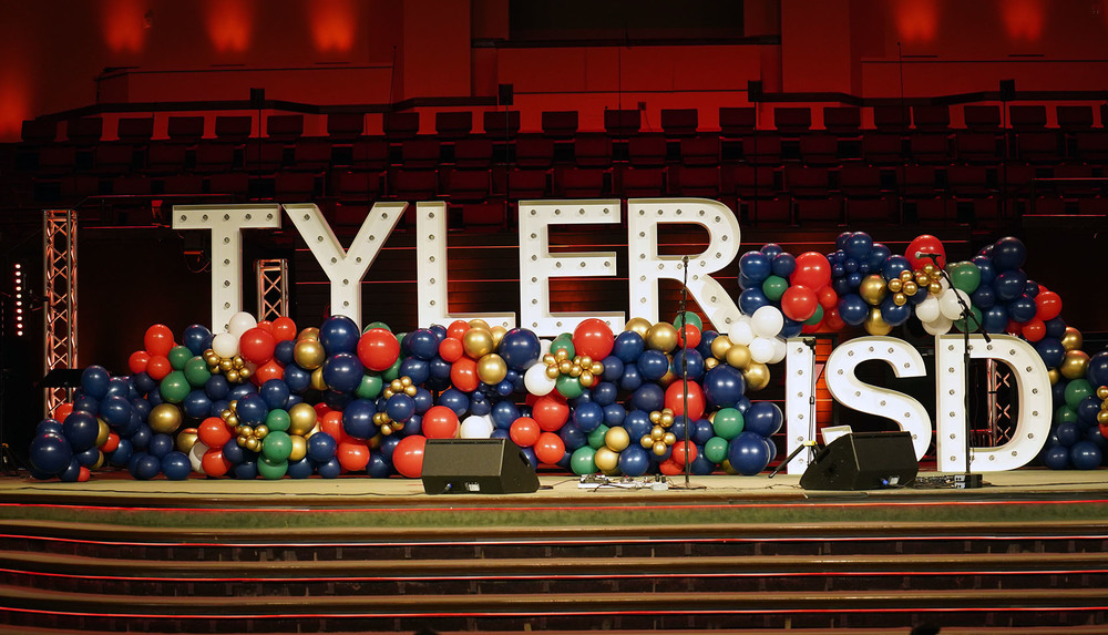 Tyler ISD letters on stage surrounded by balloons