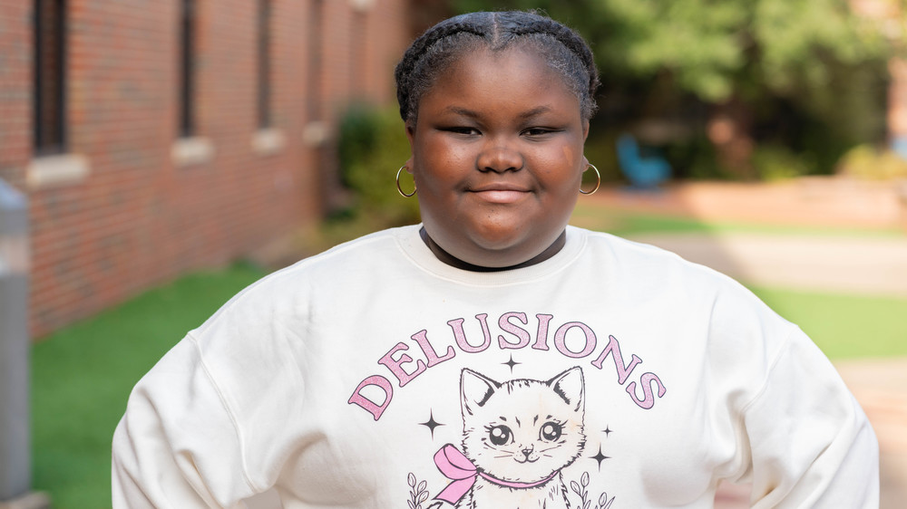 elementary age African American girl wearing cat sweatshirt smiling