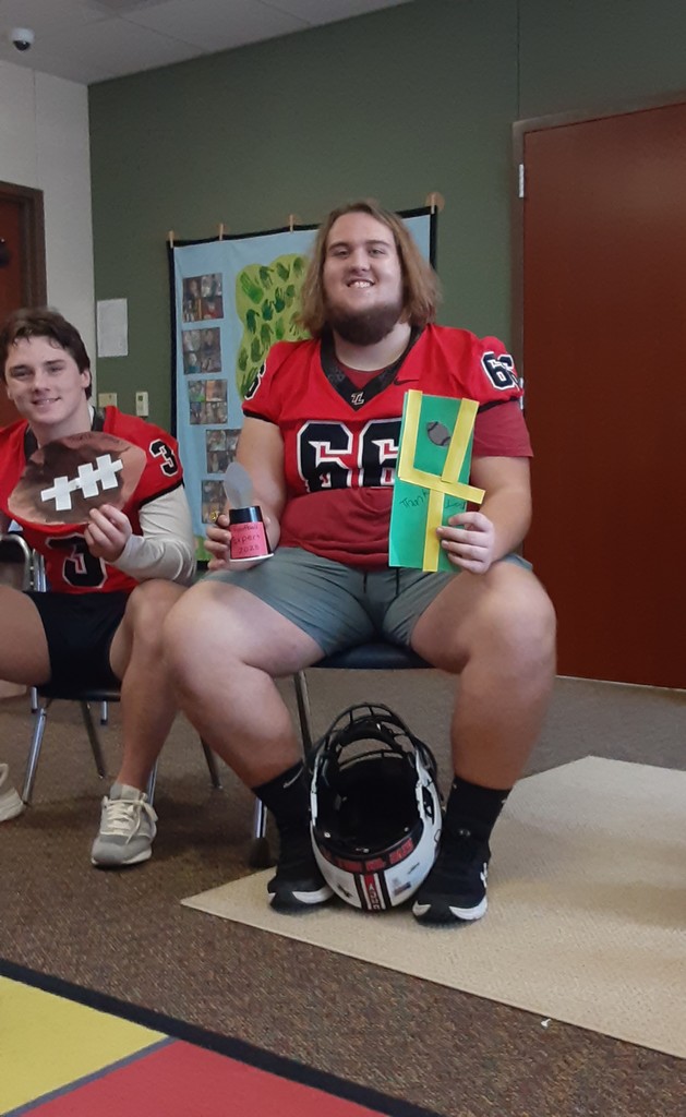 Football players holding thank you cards