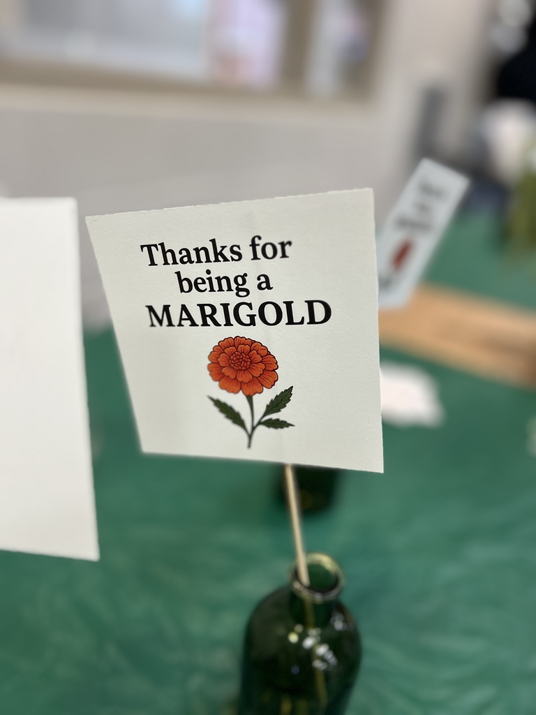 Sign in a vase that says thanks for being a marigold